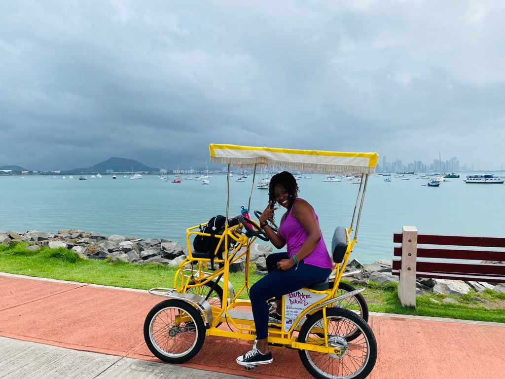 Sandra, Tax Strategist and IRS Enrolled Agent, smiling outdoors with a scenic background, representing her expertise and digital nomad lifestyle.
